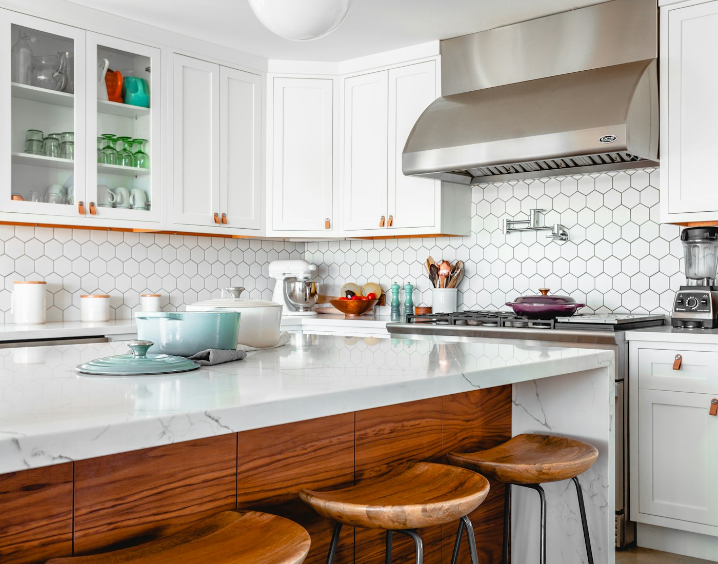 Cocina con isla de mármol y bancos de madera